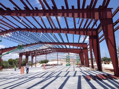 A large metal structure under construction with a blue sky in the background