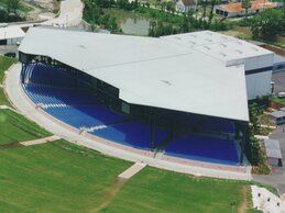 An aerial view of a large building with a swimming pool in front of it.