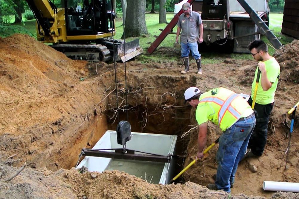 A group of construction workers are working on a septic tank.