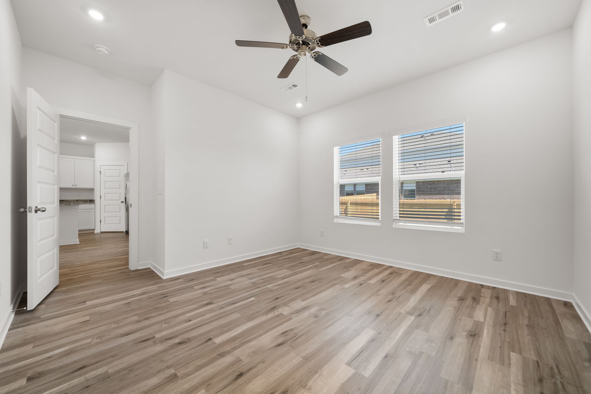 Spacious primary bedroom with large windows