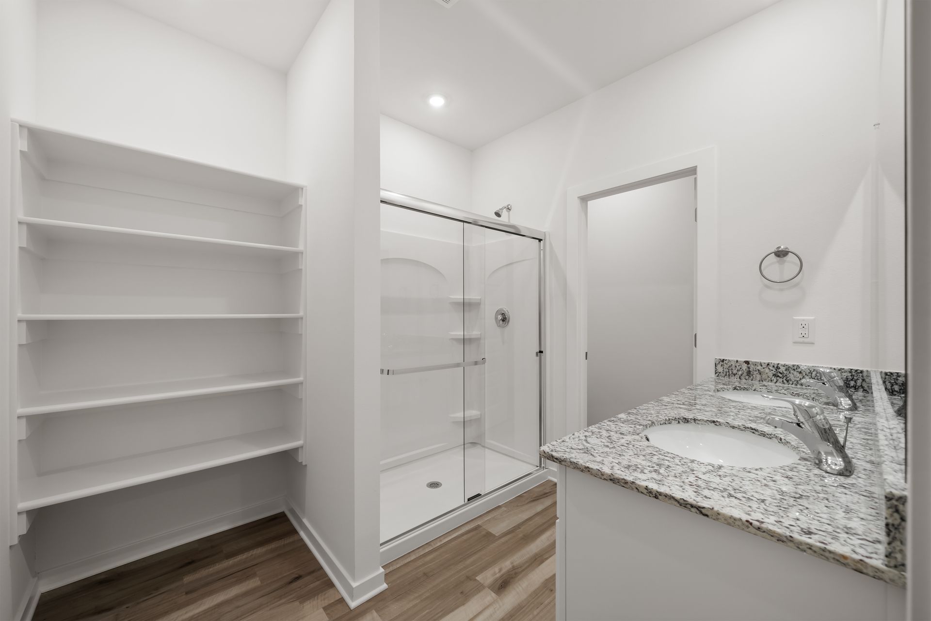 Primary bathroom with dual vanity, built-in shelving, and modern finishes