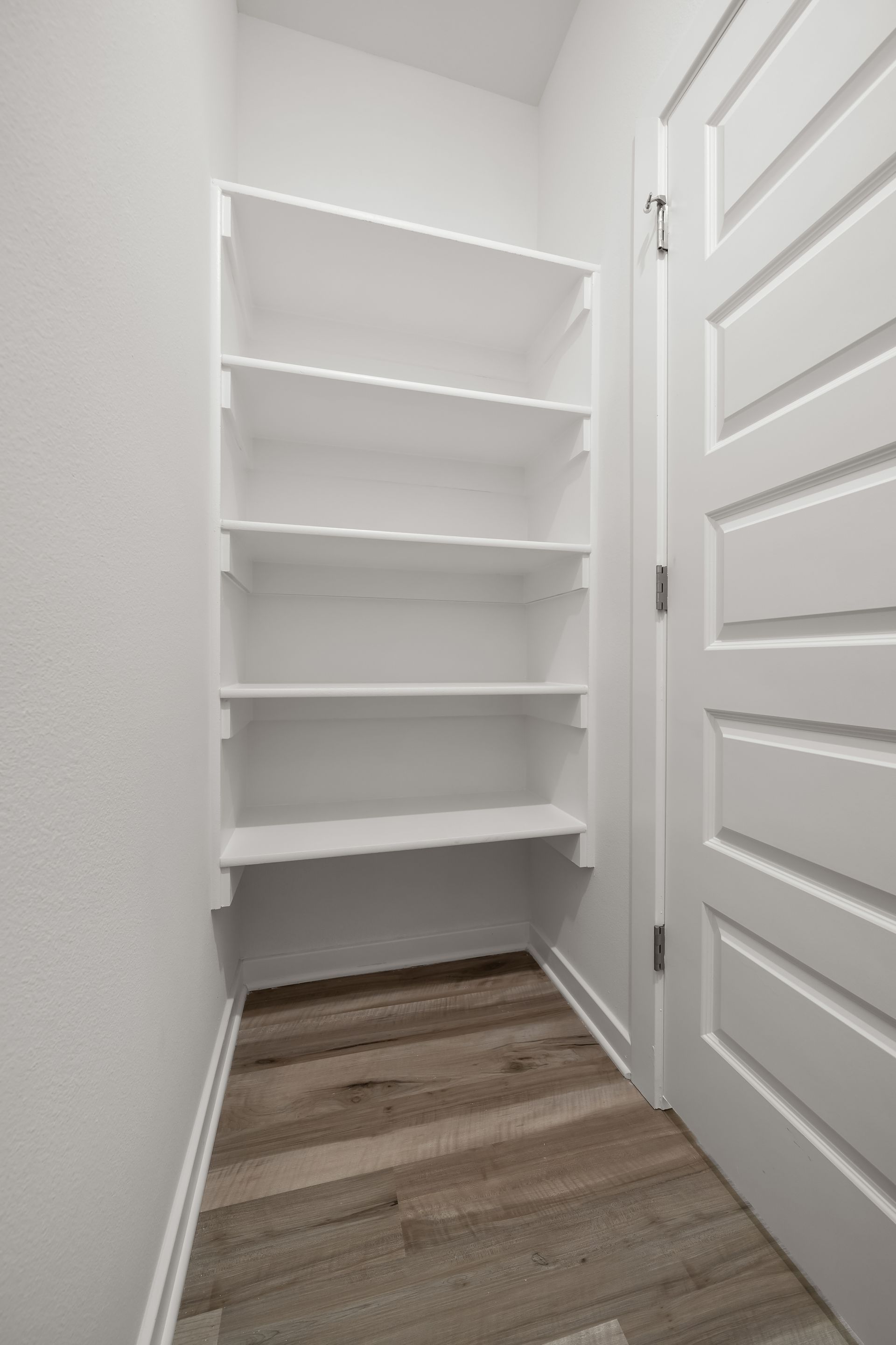 Private water closet with built-in shelving in the primary bathroom