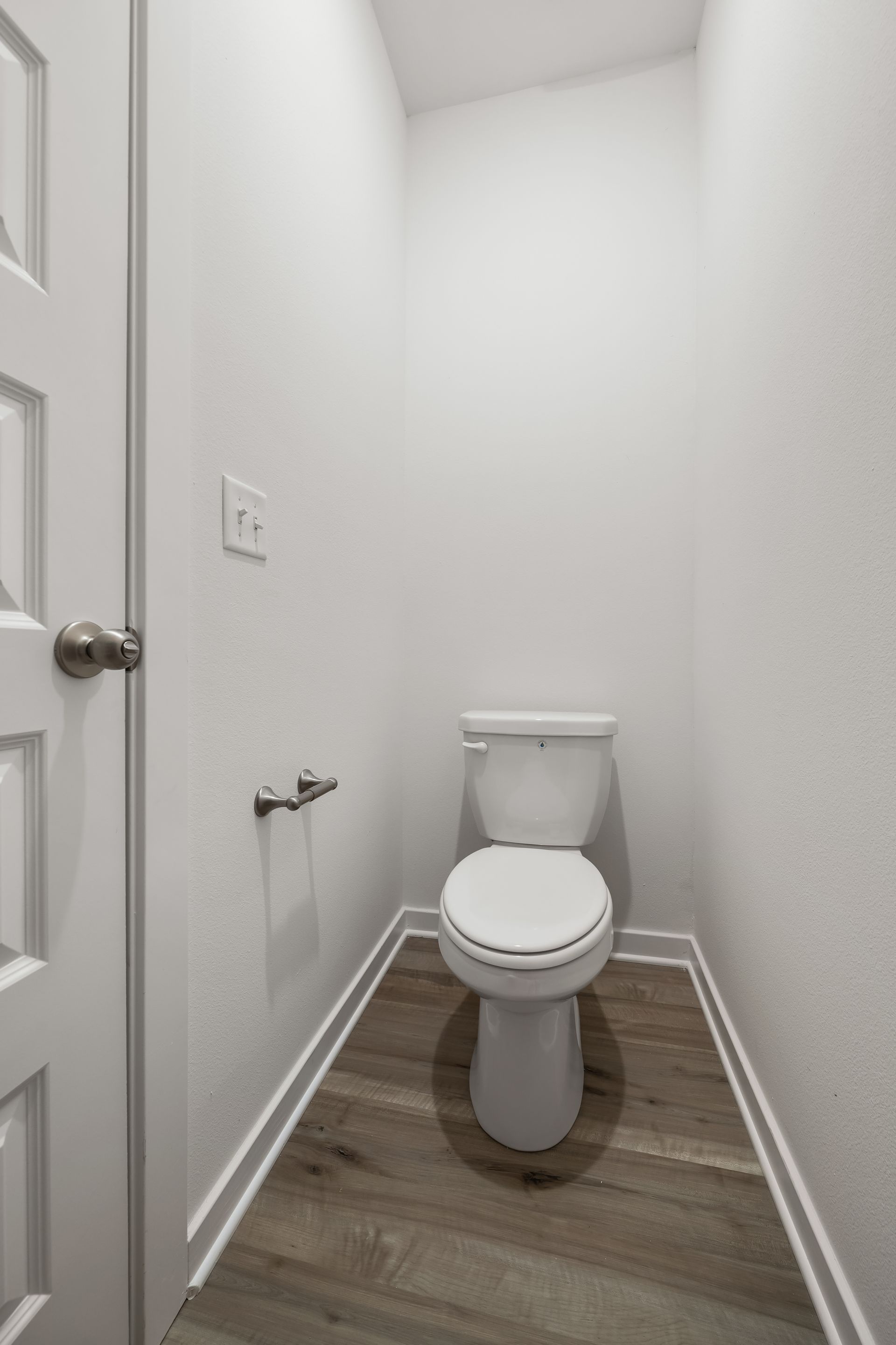 Private water closet with built-in shelving in the primary bathroom
