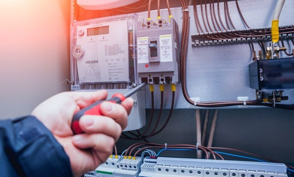 An Electrician Is Working On An Electrical Box — A.G Auto Electrical & Air-Conditioning In Hidden Valley, QLD
