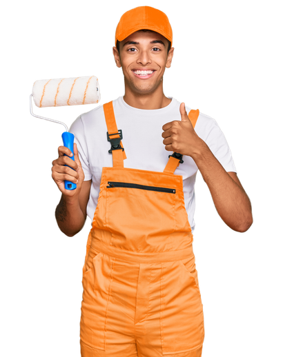 Worker in orange overalls and cap holding a paint roller and giving a thumbs up.