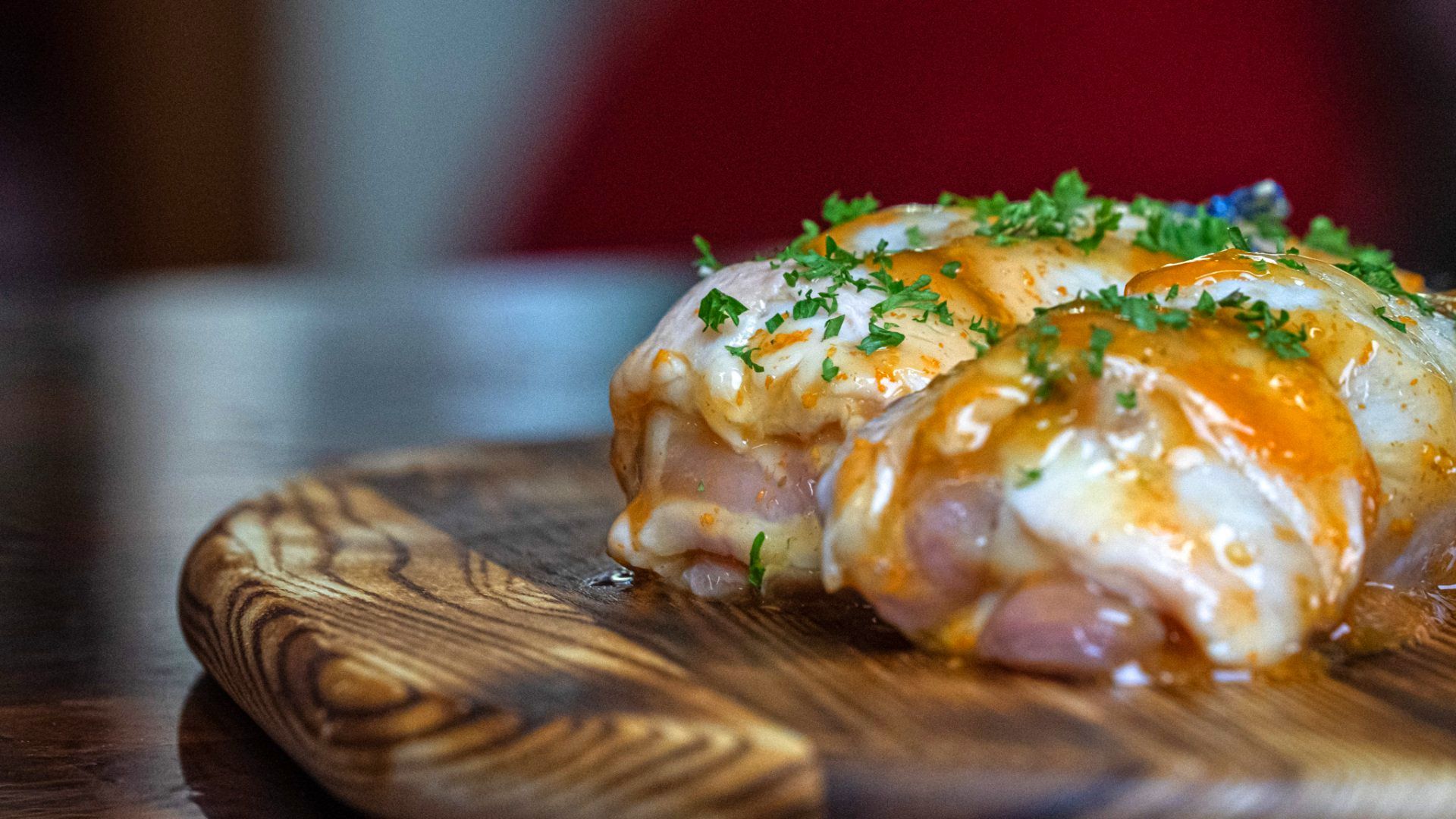 A piece of ham is sitting on top of a wooden cutting board.