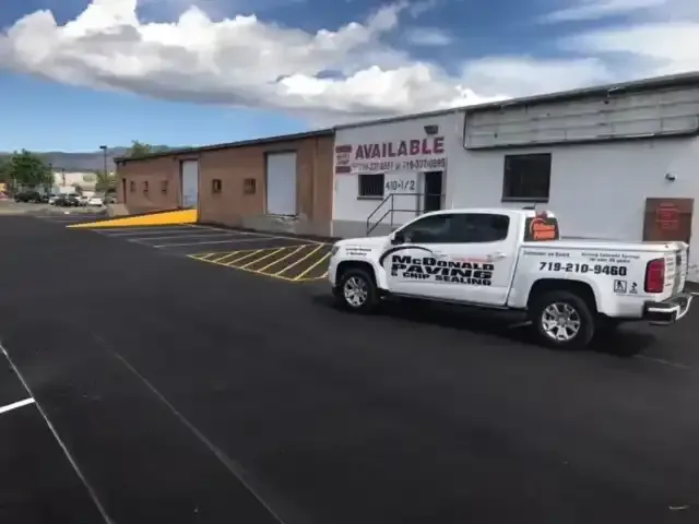 A white truck is parked in front of a building.
