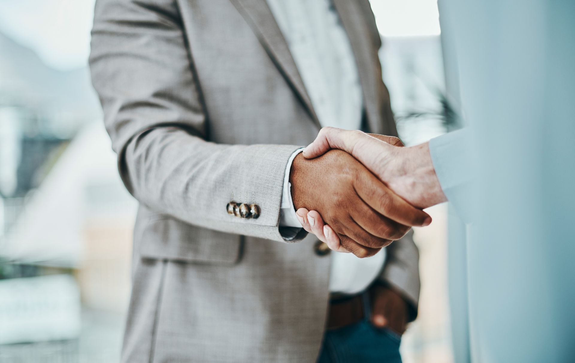 A man in a suit is shaking hands with another man.