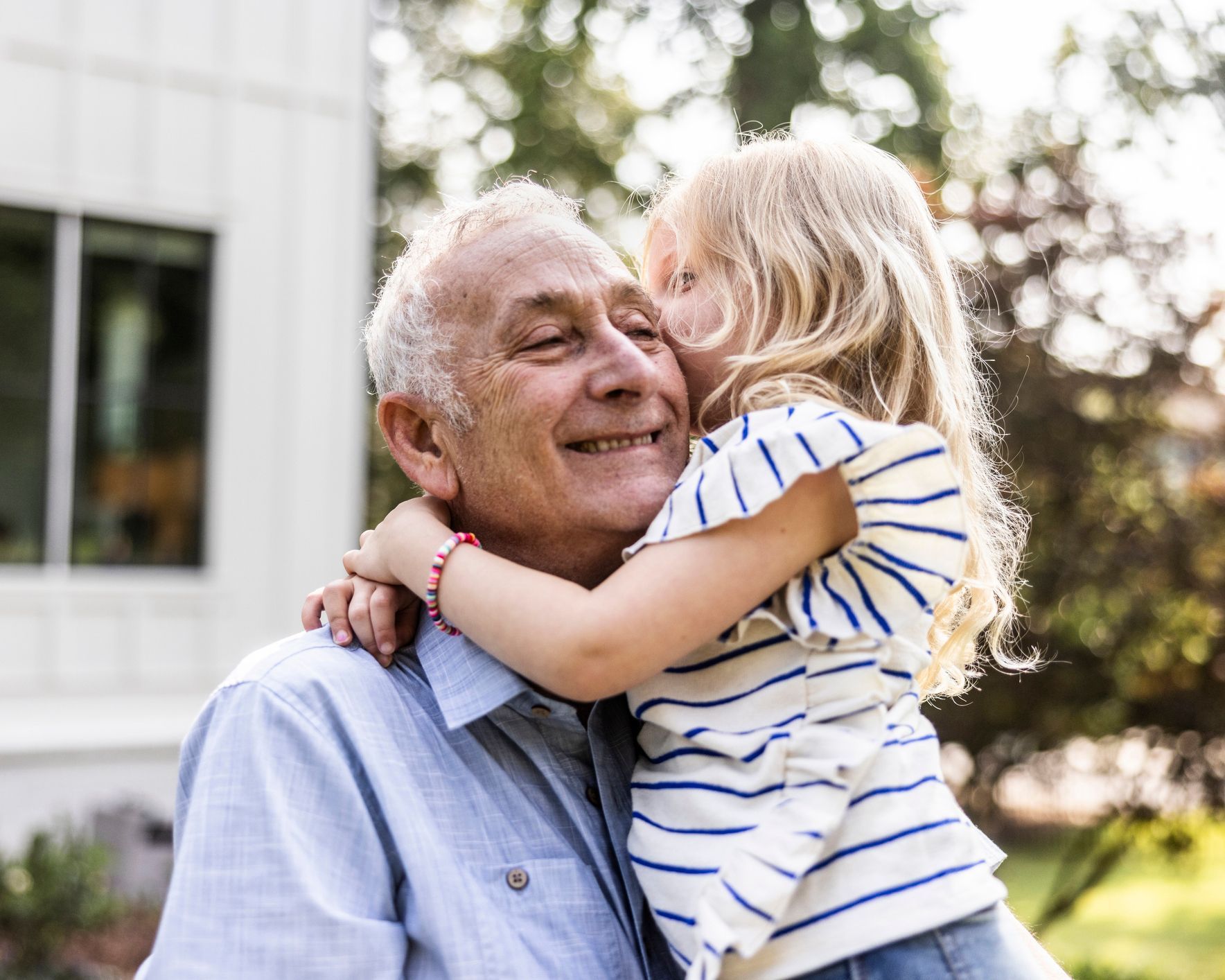 A little girl hugs an older man