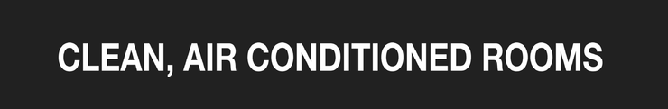White text on a black sign reading “CLEAN, AIR CONDITIONED ROOMS”