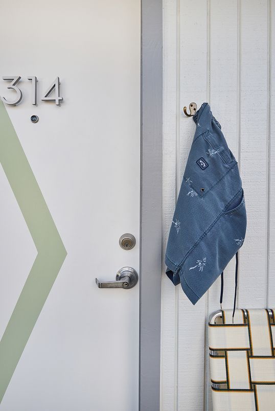 Apartment door with house number 314, blue bandana on the handle, and a bag hanging beside it.