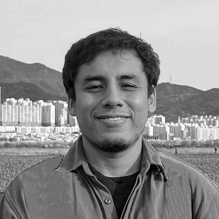 Un hombre sonríe en una foto en blanco y negro con una ciudad al fondo.