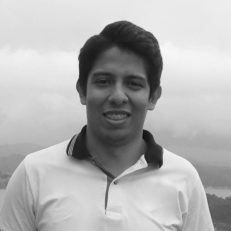 Un hombre con una camisa blanca sonríe en una foto en blanco y negro.