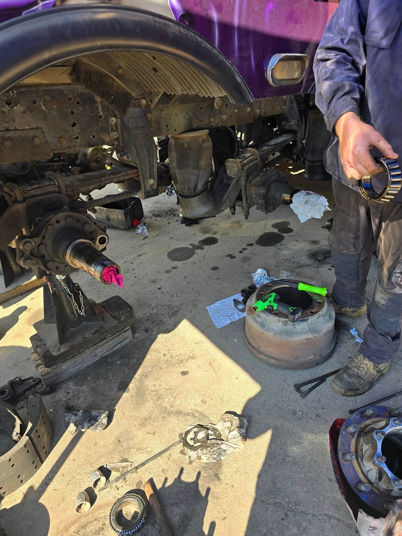 A Mechanic Works on The Exposed Wheel Assembly and Brakes of A Vehicle — Banana Coast Heavy Diesel in Wells Crossing, NSW
