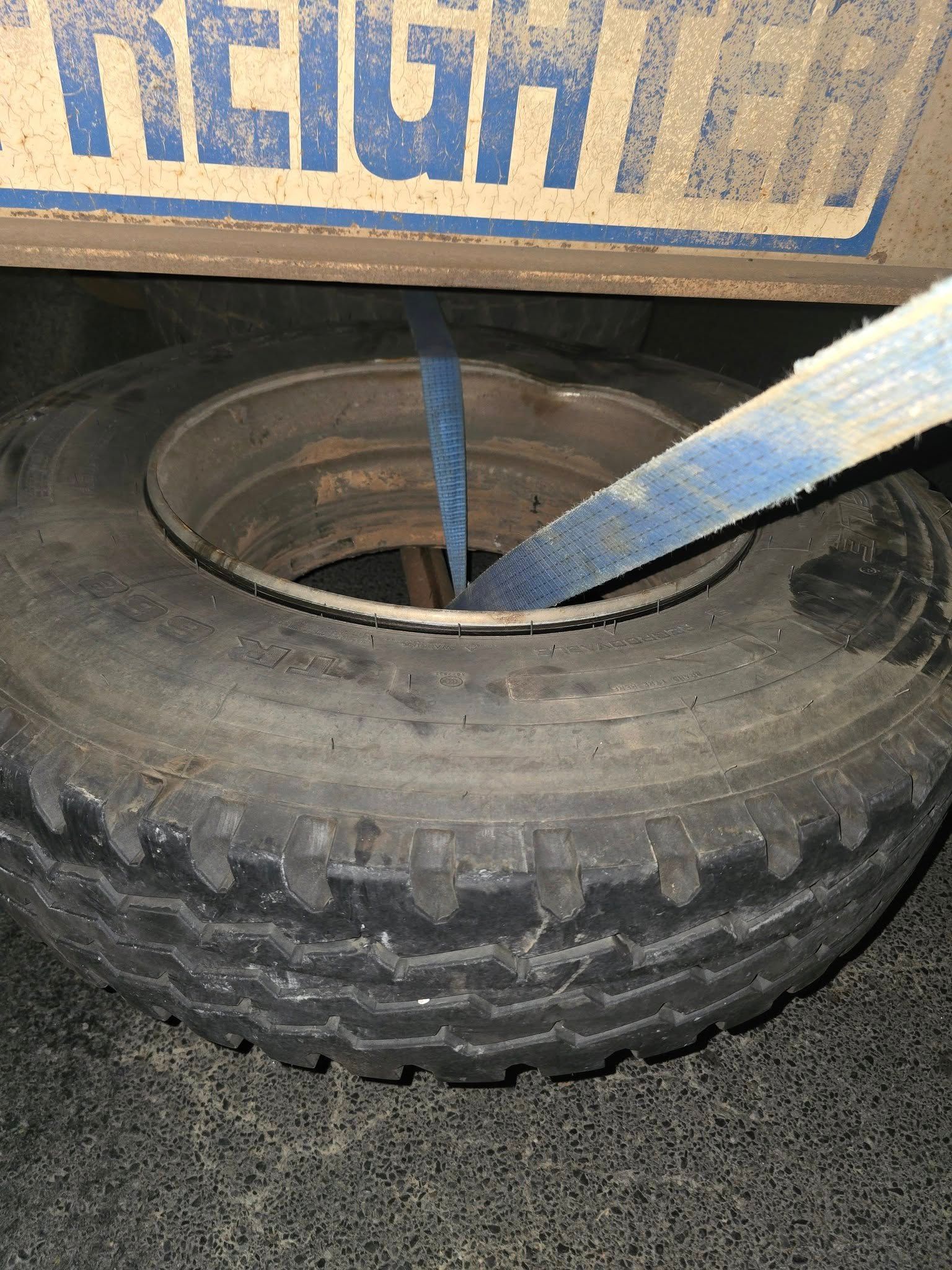 A Blue Strap Secured Through the Center of A Black Truck Tire of a Trailer — Banana Coast Heavy Diesel in Wells Crossing, NSW