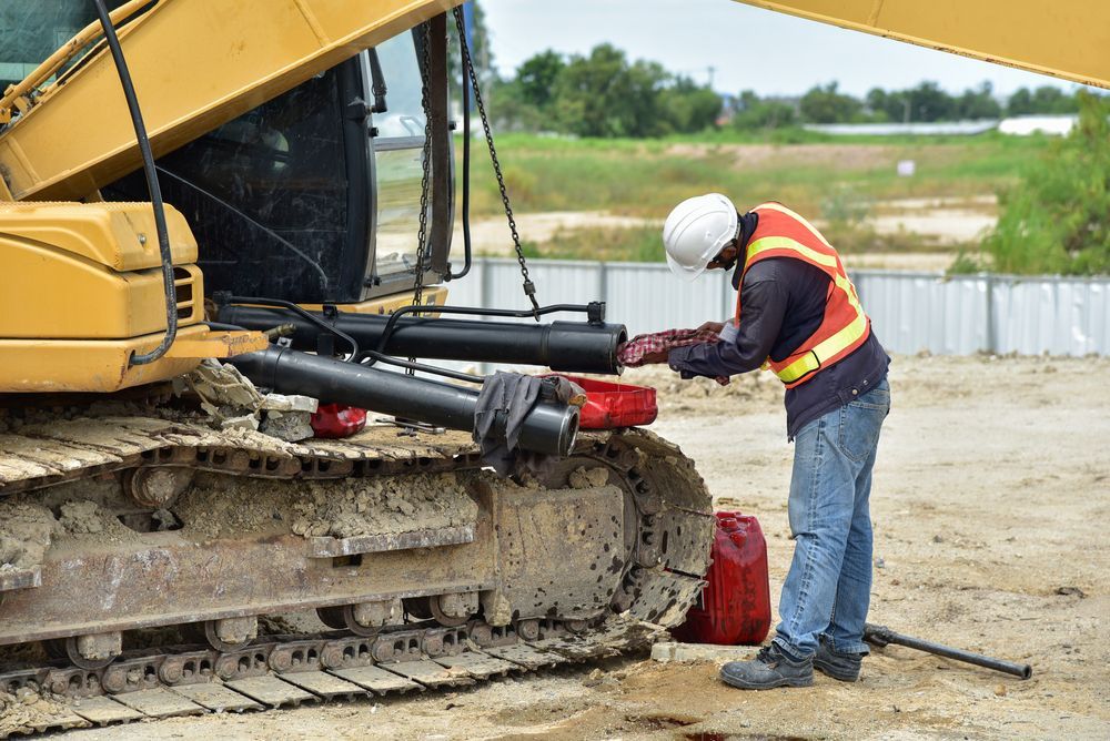 A Construction Worker Performs Maintenance on Hydraulic of An Excavator — Banana Coast Heavy Diesel in Nambucca Heads, NSW