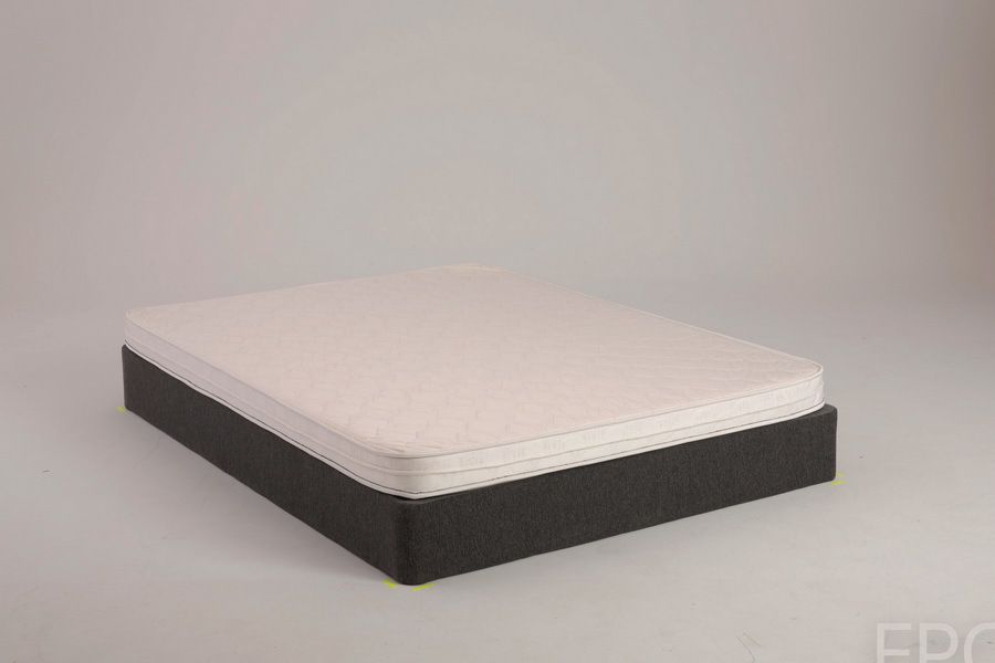 A mattress on a dark gray foundation against a white background.