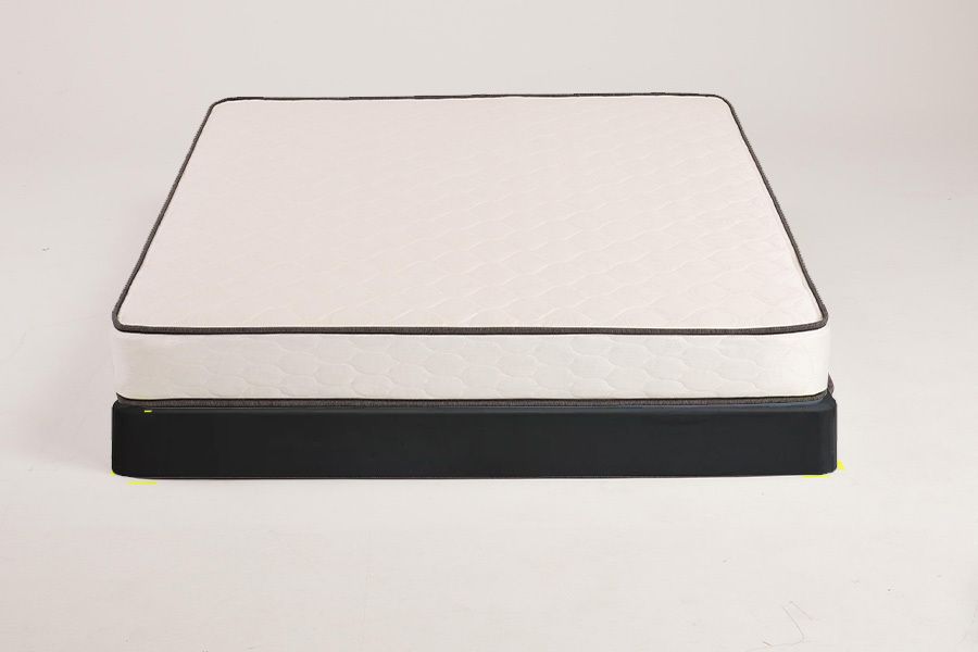 White mattress with black trim on a black base.