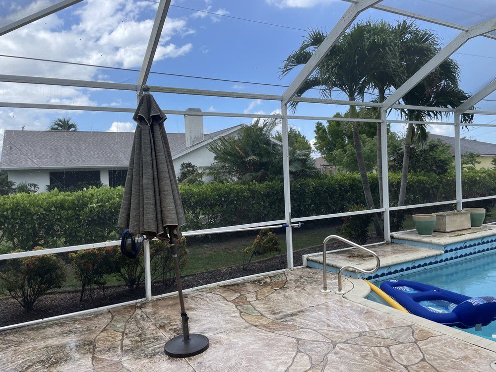 A screened in swimming pool with a table and chairs