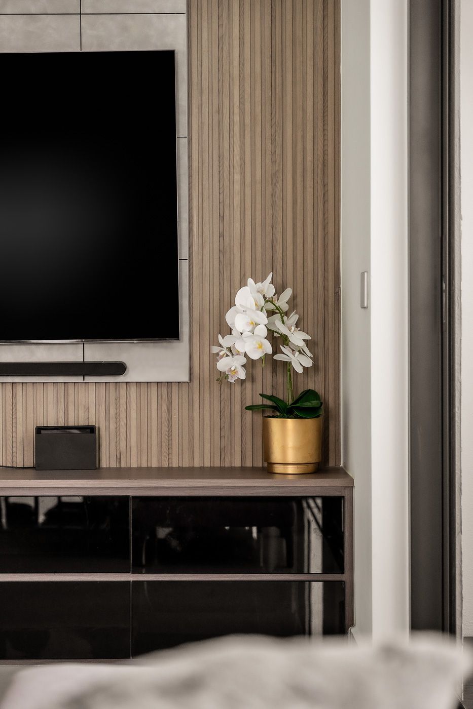 A living room with a tv and a potted plant on a table.
