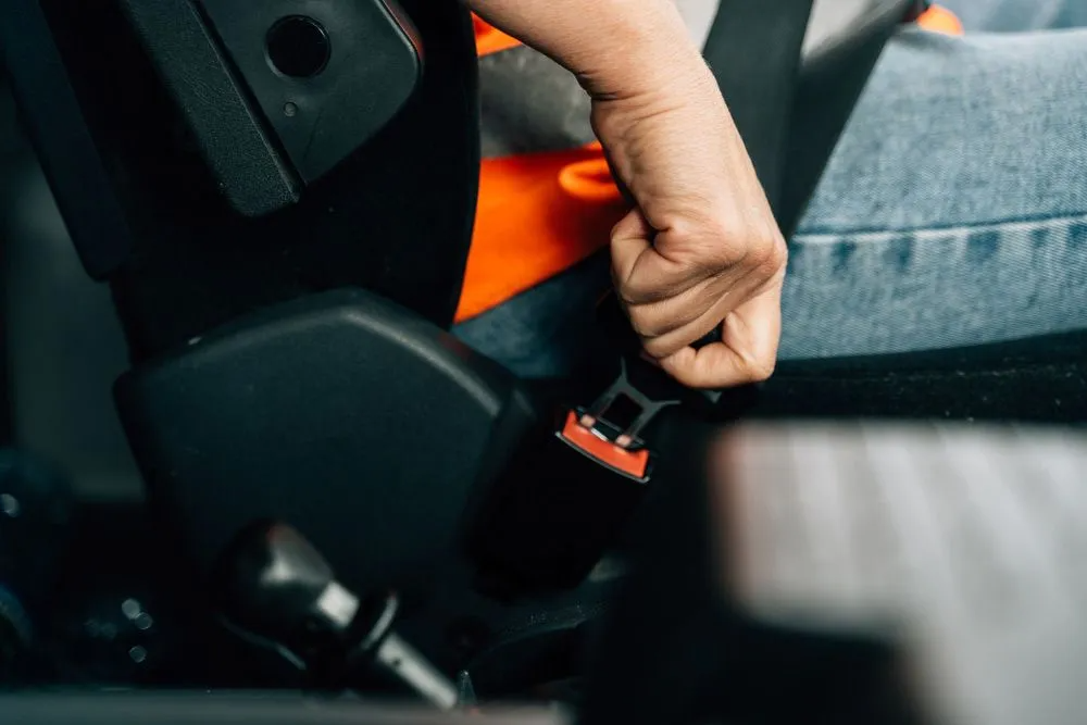 A Person is Putting on a Seat Belt in a Car — Truck Training and Assessments In Umina Beach, NSW