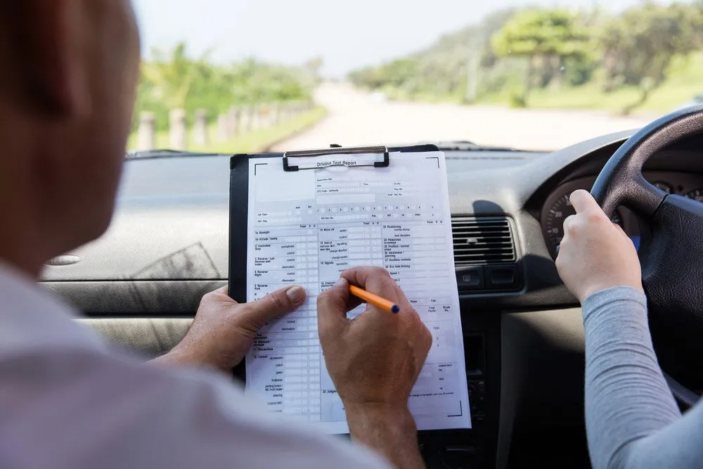 A Man and a Woman Are Taking a Driving Test in a Car — Truck Training and Assessments In Umina Beach, NSW