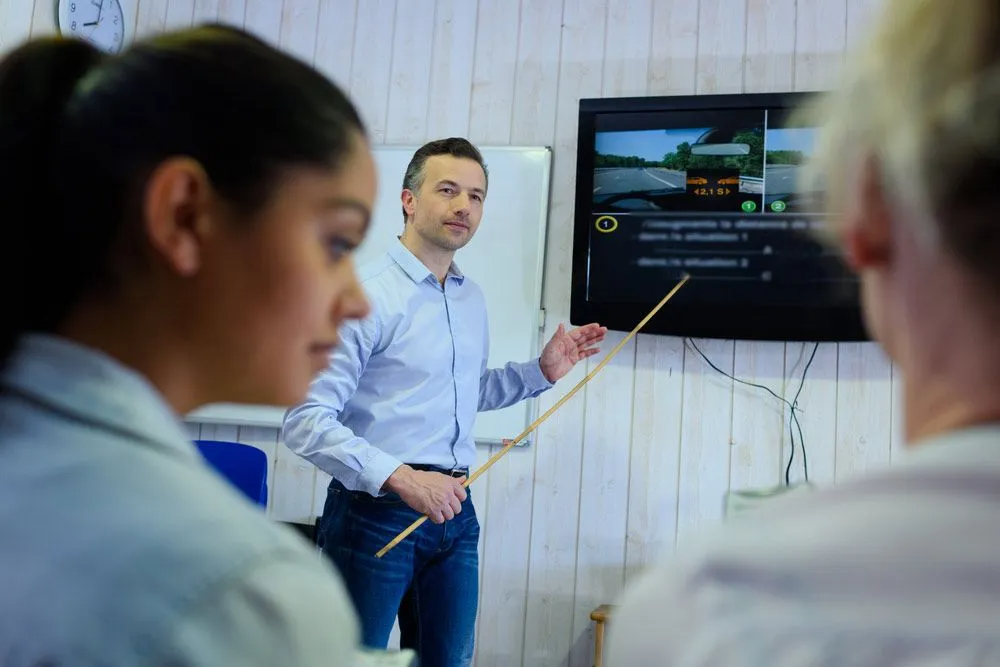 A Man is Giving a Presentation to a Group of People in a Classroom — Truck Training and Assessments In Umina Beach, NSW