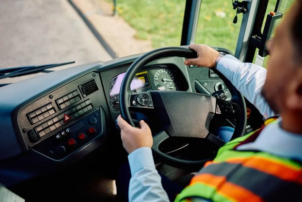 A Man is Driving a Bus on a Road — Truck Training and Assessments In Umina Beach, NSW