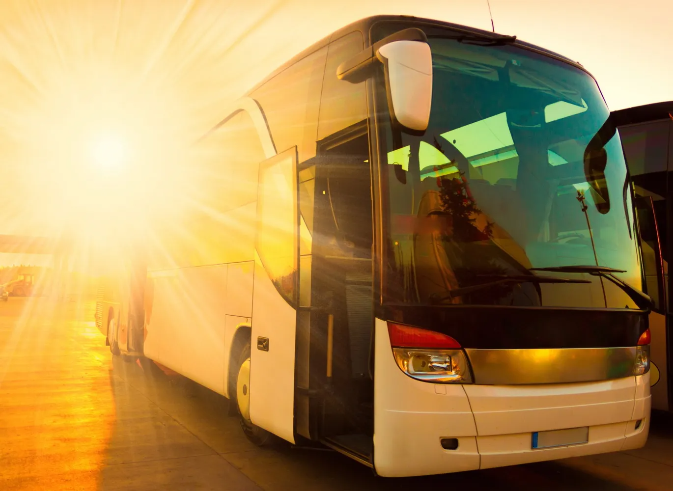 A Bus is Parked on the Side of the Road at Sunset — Truck Training and Assessments In Umina Beach, NSW