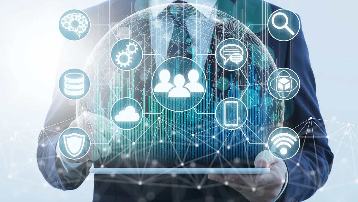 A man in a suit is holding a tablet with a globe and icons on it.