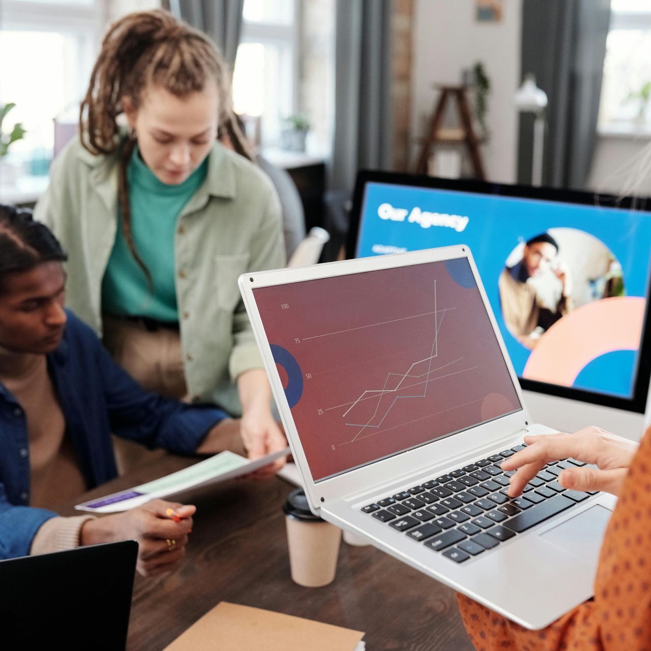 A group of people are sitting at a table using laptops.
