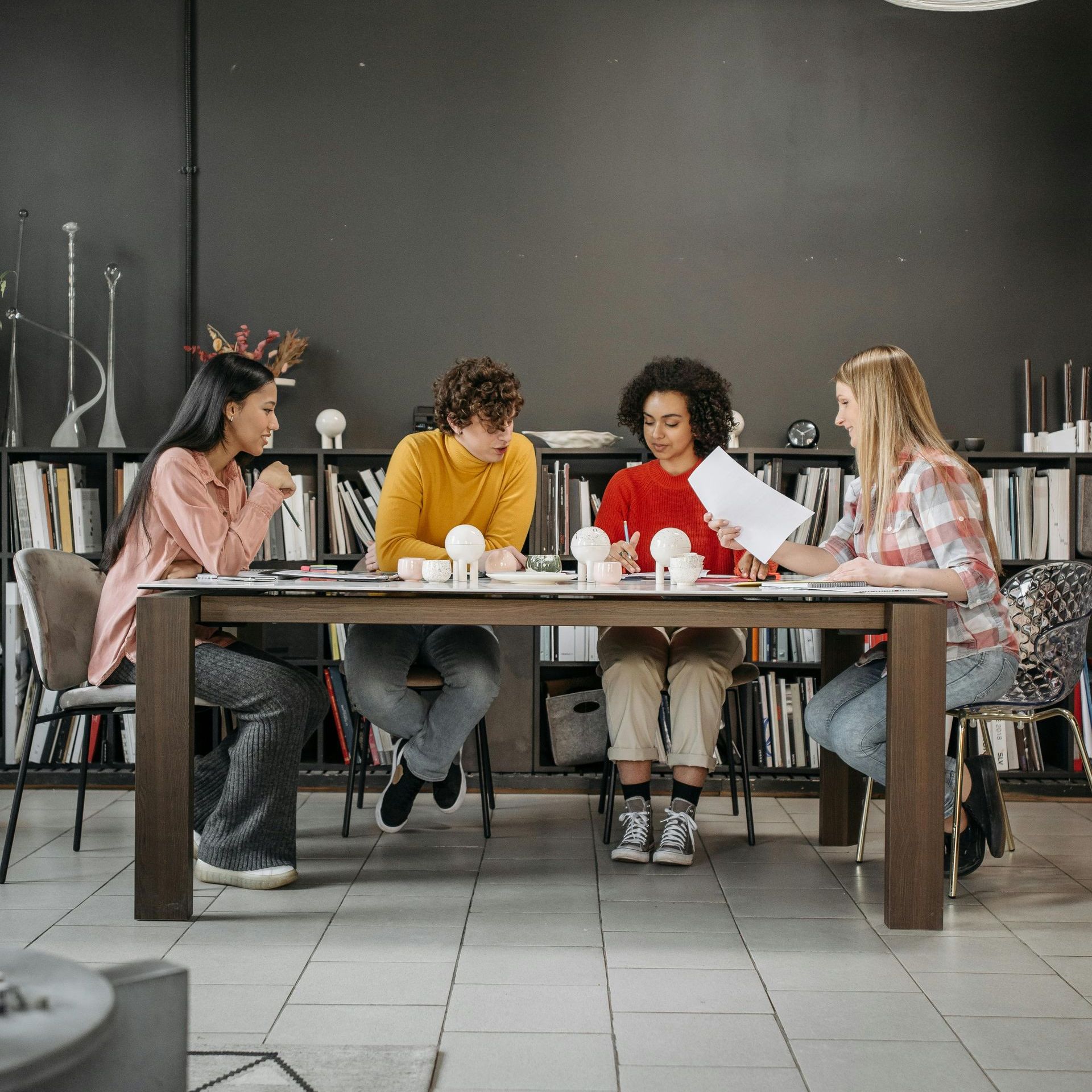 A group of people are sitting around a table looking at papers