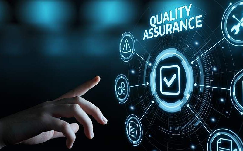 A person is pressing a button on a screen that says quality assurance.