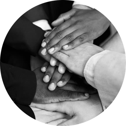 A group of people are putting their hands together in a circle.