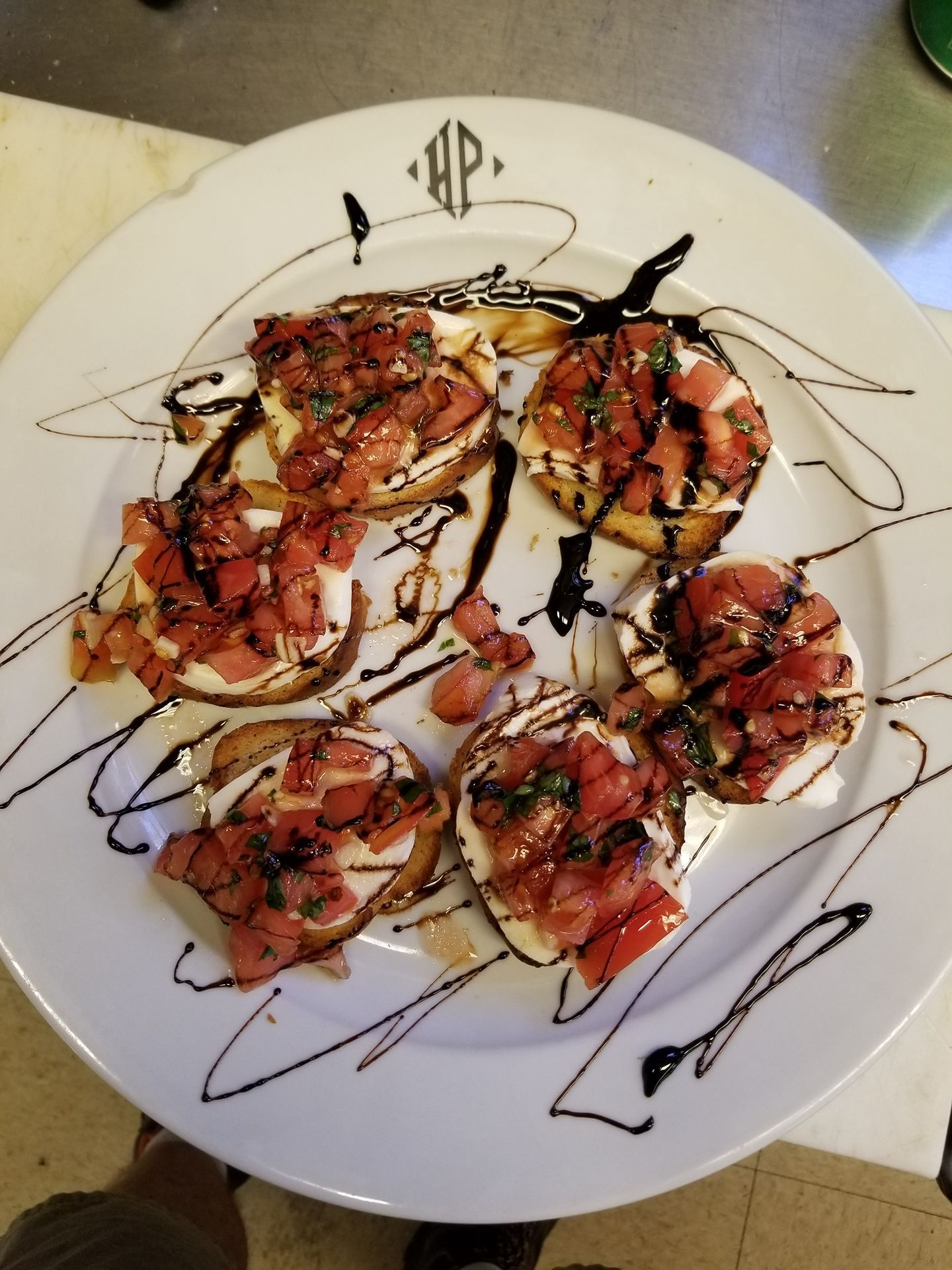 Plate of garnished shrimp over sauce, drizzled with balsamic glaze on a white plate