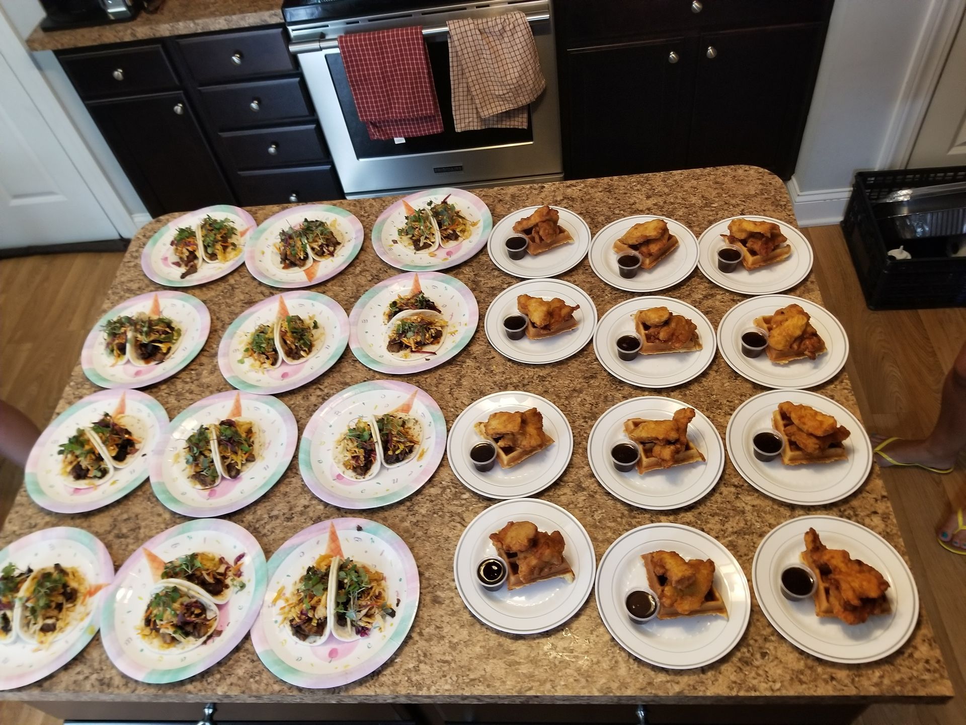 Plates of plated food arranged on a kitchen counter, ready to serve.