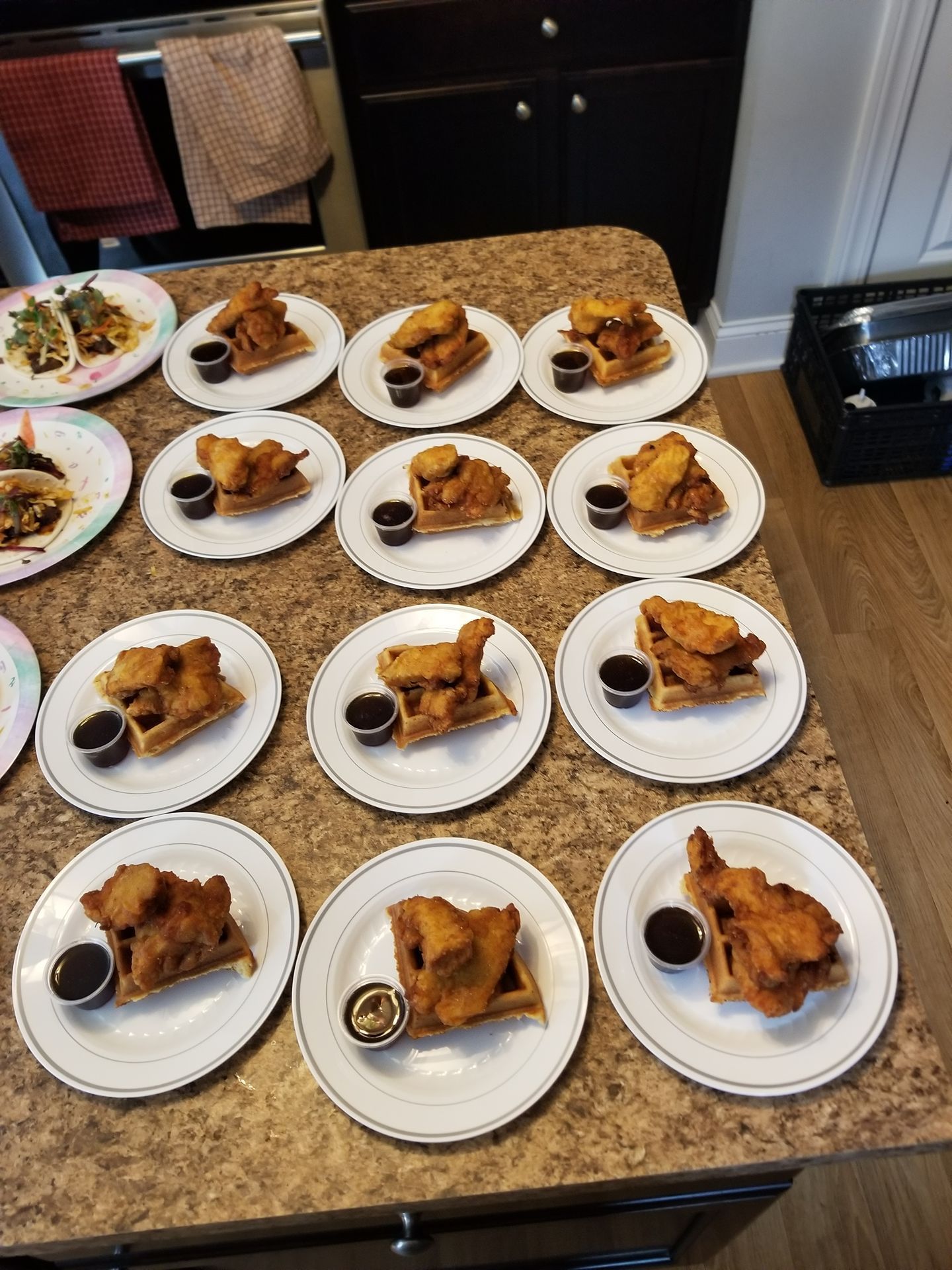 Plates of plated food arranged on a kitchen counter, ready for serving.