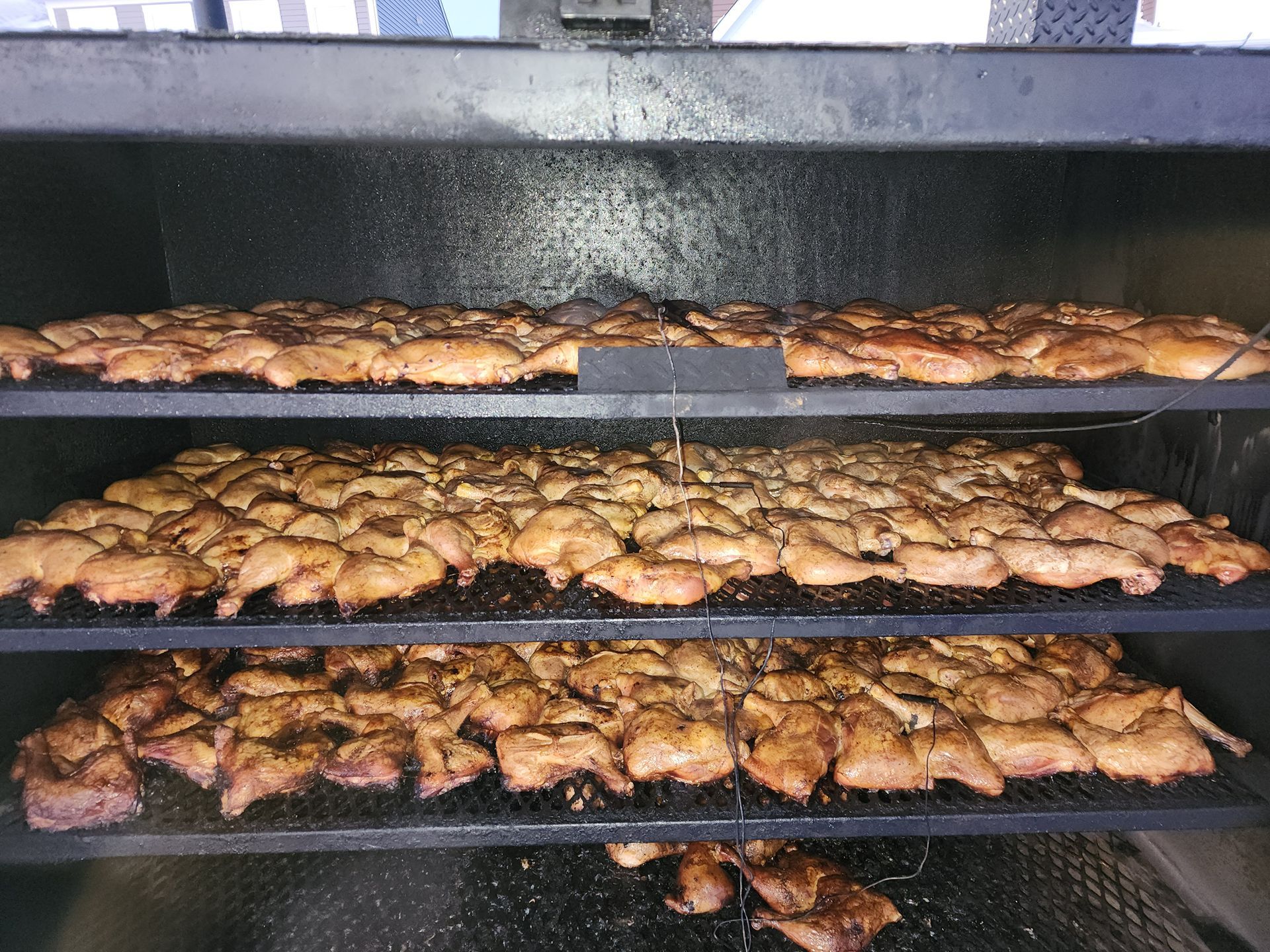 Trays of roasted chicken pieces cooking in a commercial oven