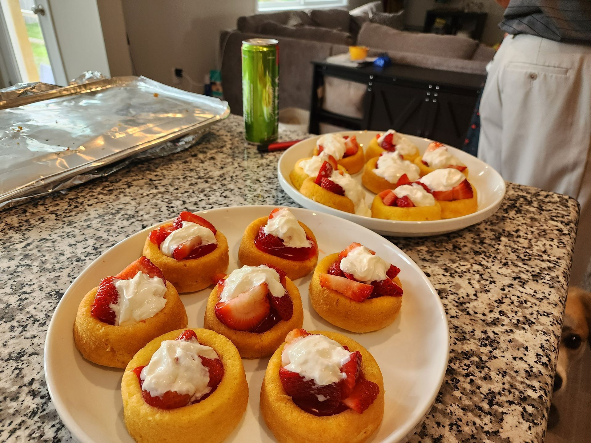 Plate of mini fruit tarts on a kitchen counter, with more tarts in a bowl nearby.
