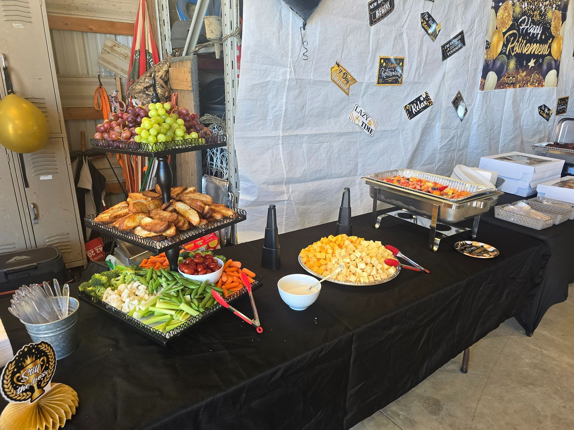 Buffet table with trays of appetizers, fruit, chips, and dip in a decorated indoor setting