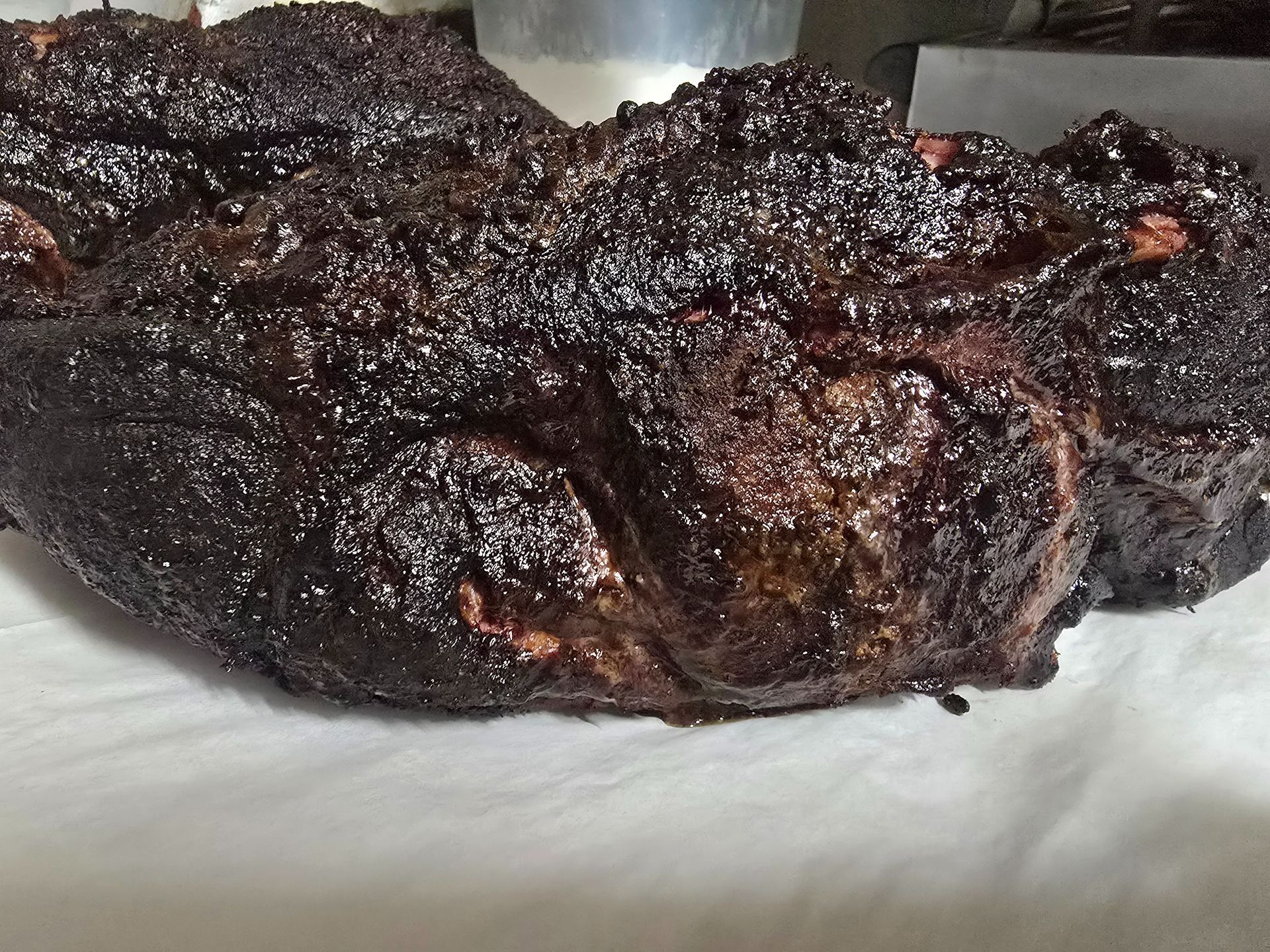 Dark, charred grilled meat on a white plate