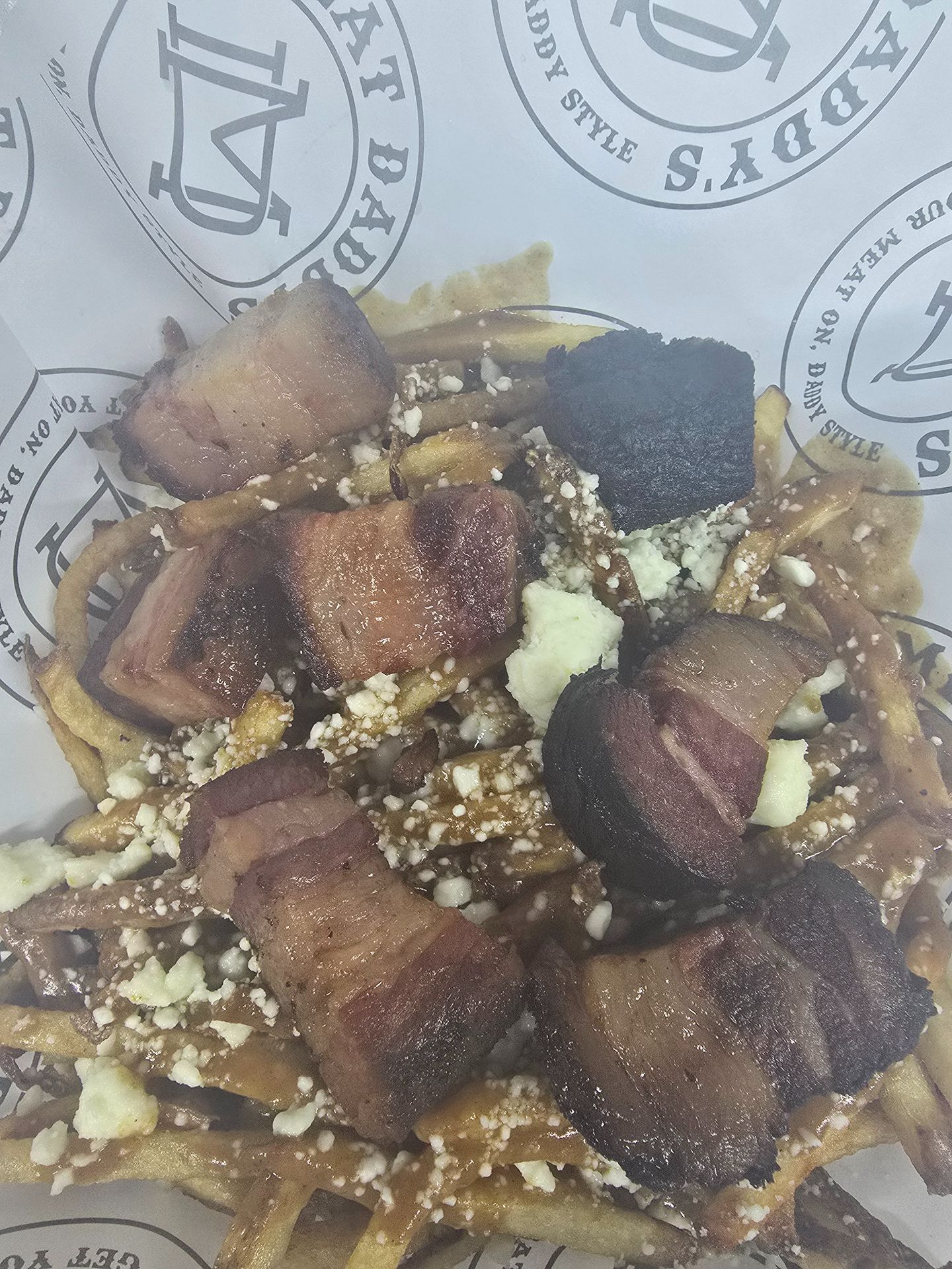 Grilled meat cubes with rice and bread in a paper-lined tray