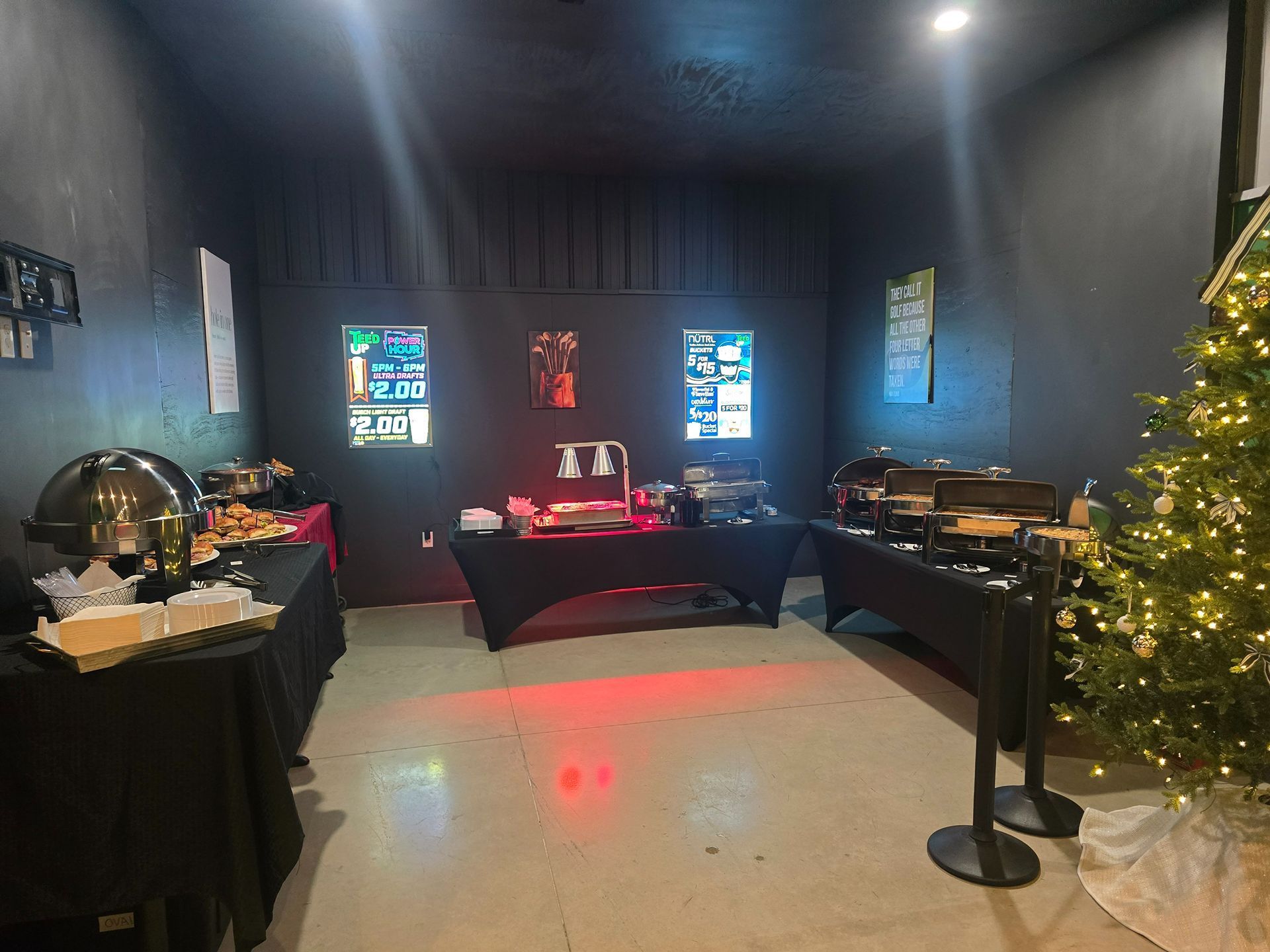 Dim room with memorial tables, glowing stained-glass windows, and a lit Christmas tree on the right.