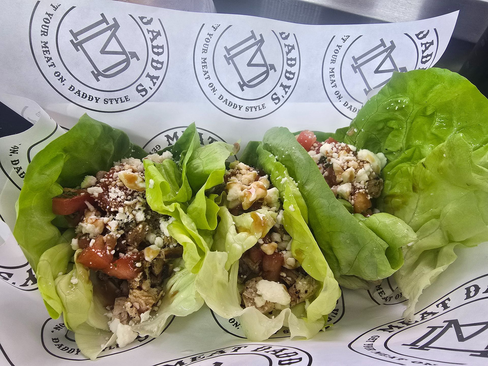 Lettuce wraps filled with a grain-and-vegetable mixture on branded paper liner