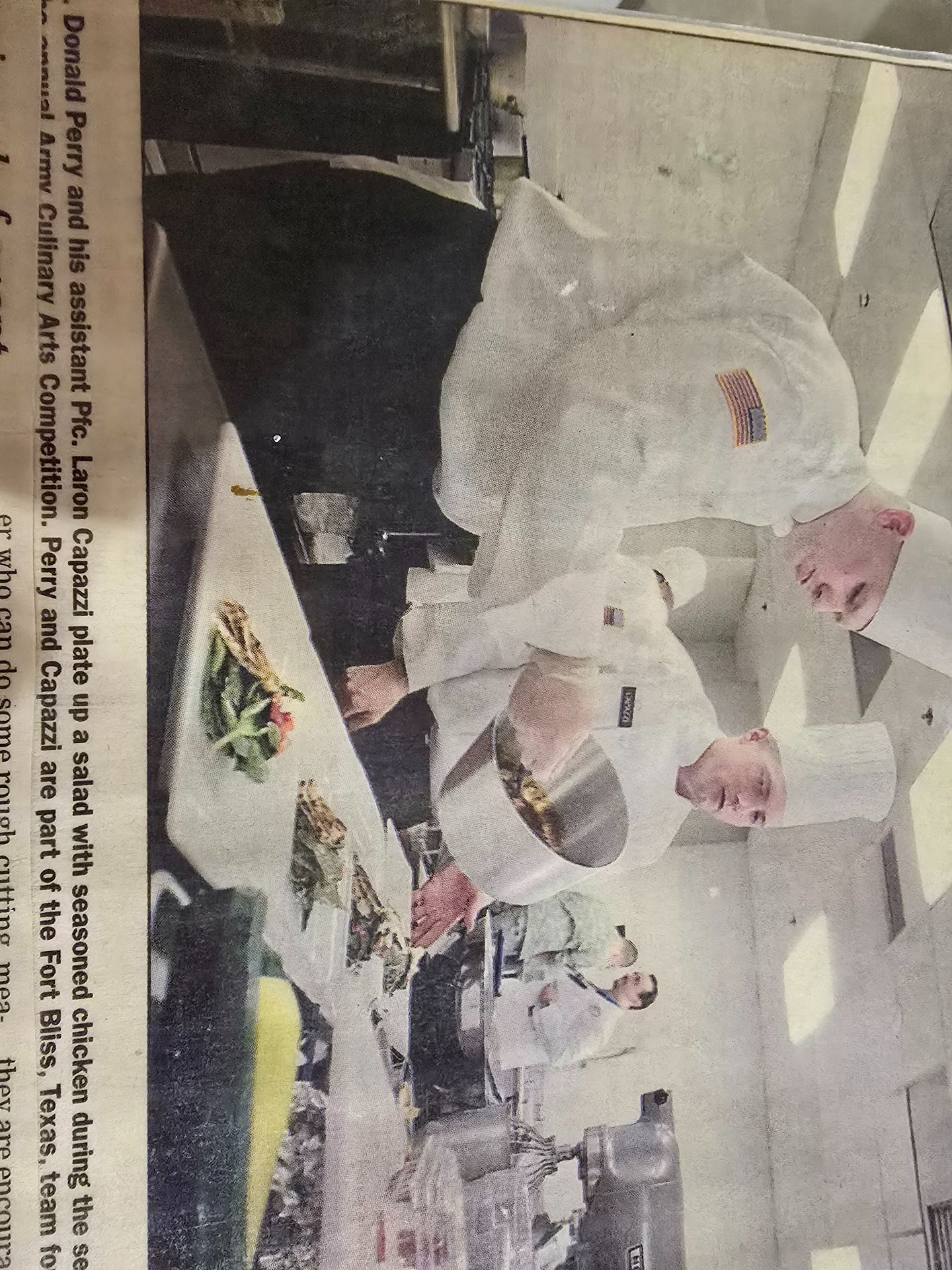 Chefs in white uniforms and hats preparing food in a bright commercial kitchen