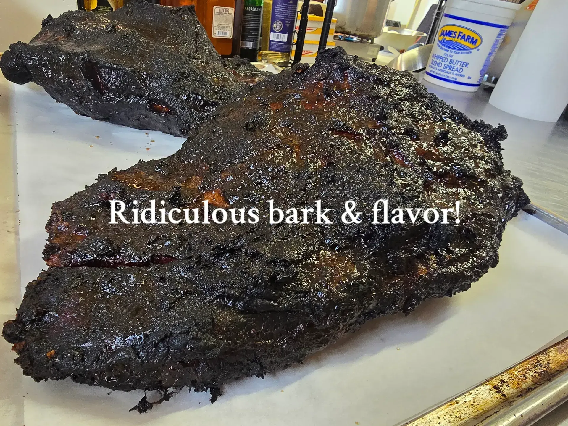 Charred bark-covered smoked meat on a tray, with text reading “Ridiculous bark & flavor!”