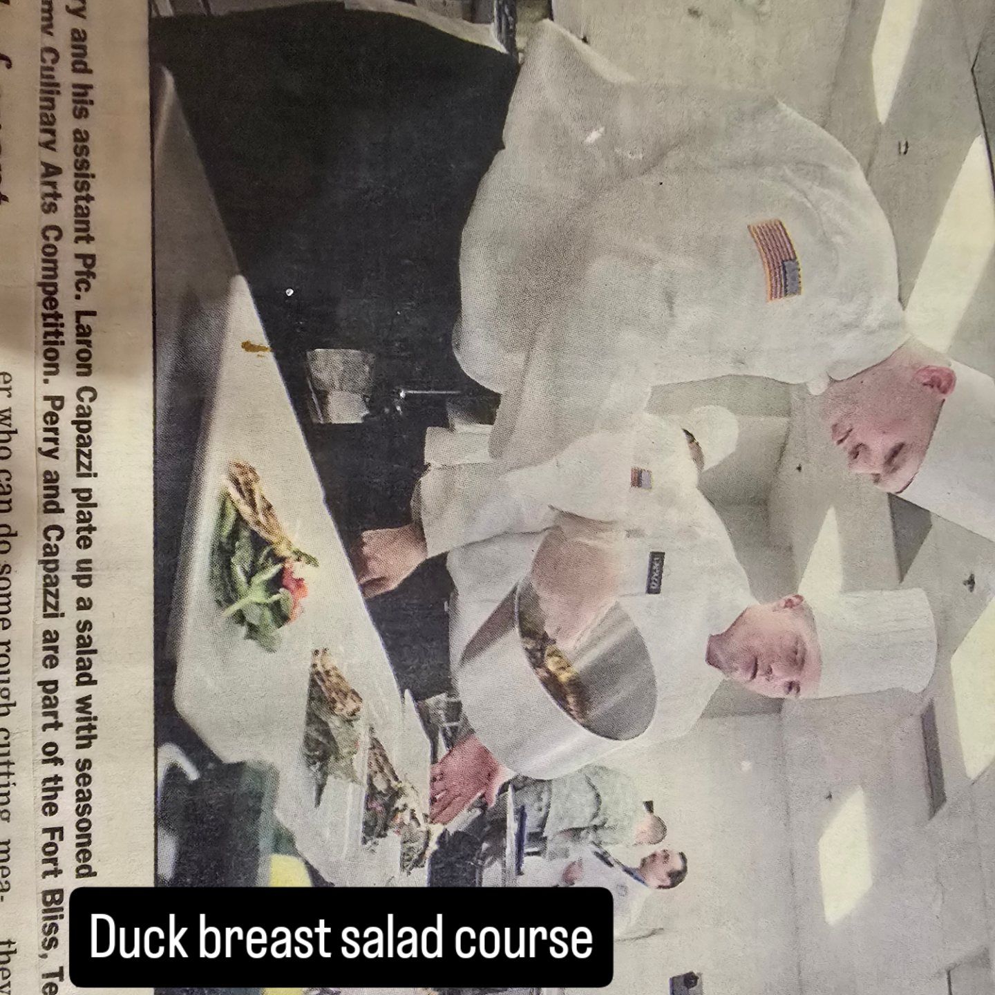 Chef presenting duck breast salad course in a kitchen, with plated dish on the counter