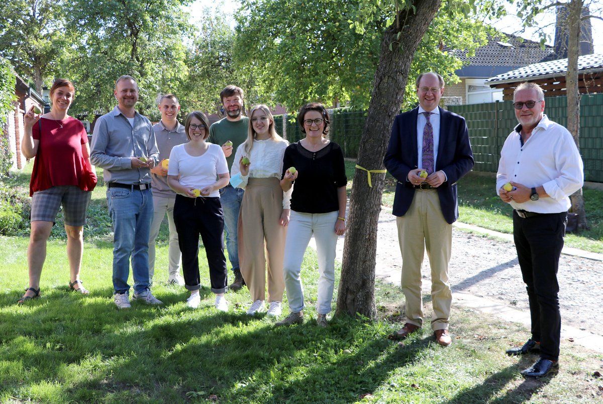 Das gelbe Band kennzeichnet Bäume, von denen das Obst geerntet werden darf. Cornelia Mealing (Stadt Sendenhorst), Tom Hofmann (Kreis Warendorf), Hendrik Veith (Stadt Sassenberg), Sarah Strupat (Stadt Ennigerloh), Hans Jürgen Dirks (Gemeinde Beelen), Anastasia Schiller (Stadt Ennigerloh), Daniela Puppe (Kreis Warendorf), Landrat Dr. Olaf Gericke und Ennigerlohs Bürgermeister Berthold Lülf hoffen, dass viele Früchte zu Kuchen, Saft oder Marmelade verarbeitet werden.