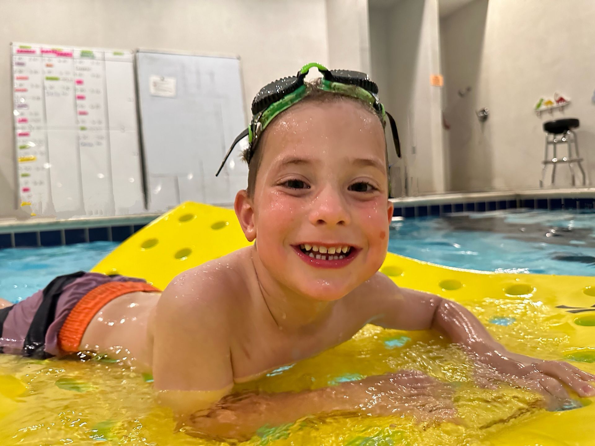 Young boy at private swim lesson in Wheat Ridge Colorado, on a flotaion device.