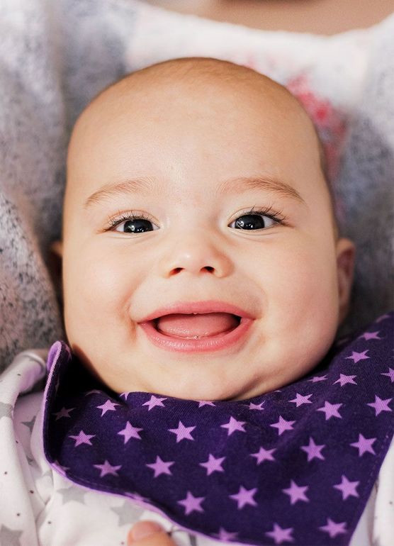 Smiling baby in a purple star-patterned scarf